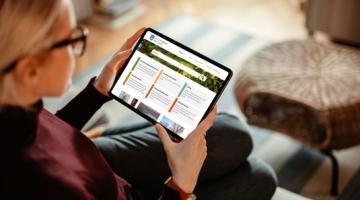 Lady holding a tablet with the East Cambs website on